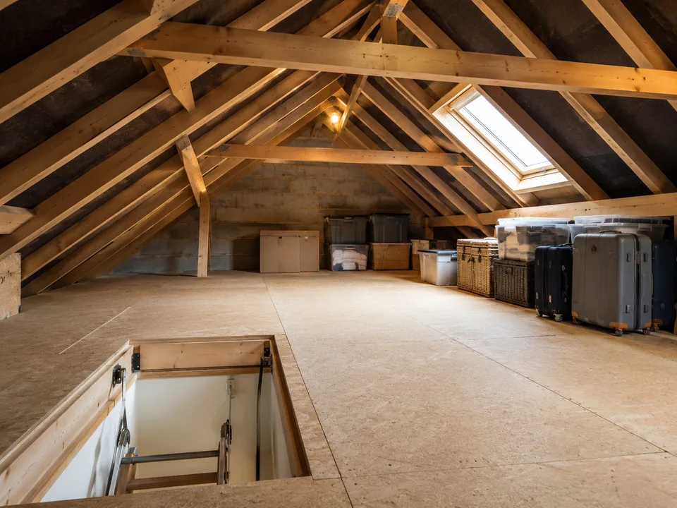 Boarded loft storage space with timber roof structure and organised storage